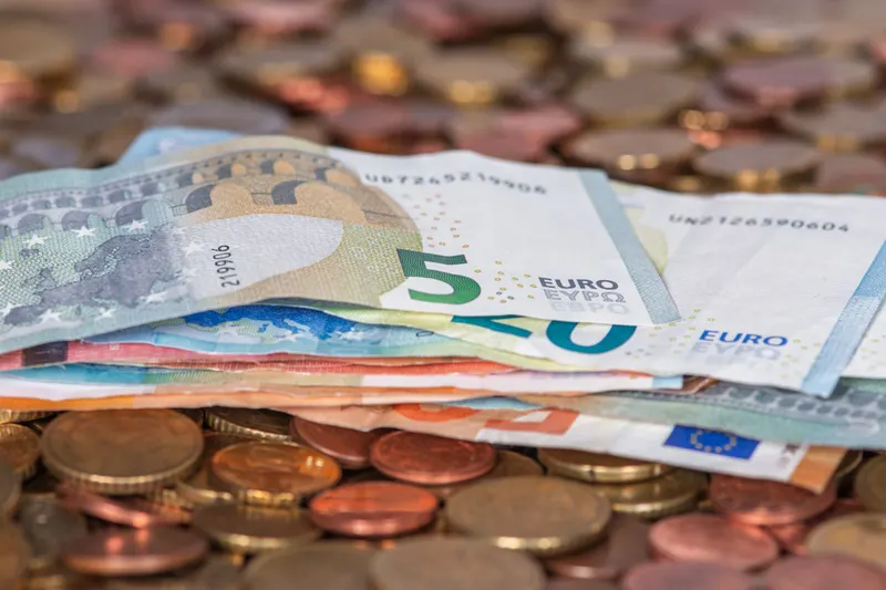 Eurobiljetten en euromunten op tafel als beeld van het loon in elke fase